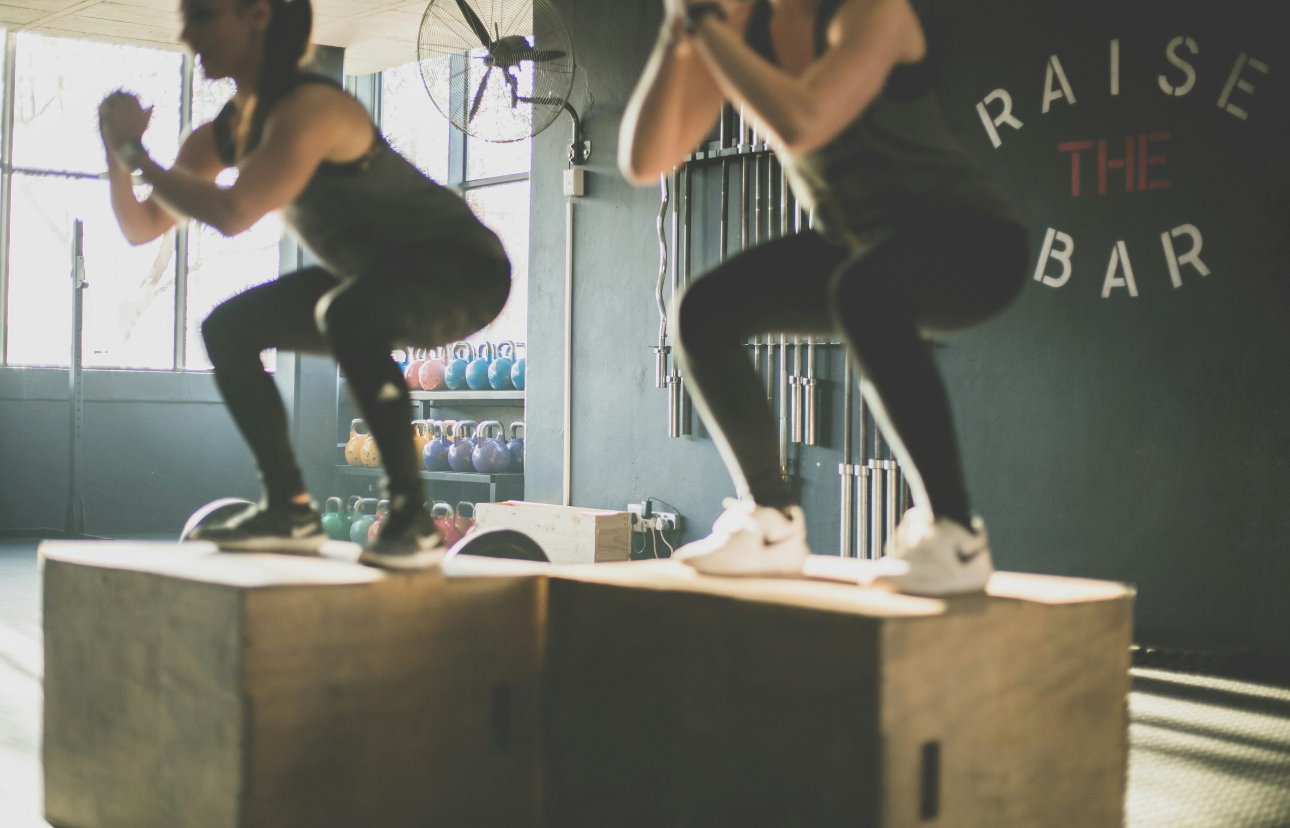 Twee sporters doen samen box jumps tijdens duo personal training