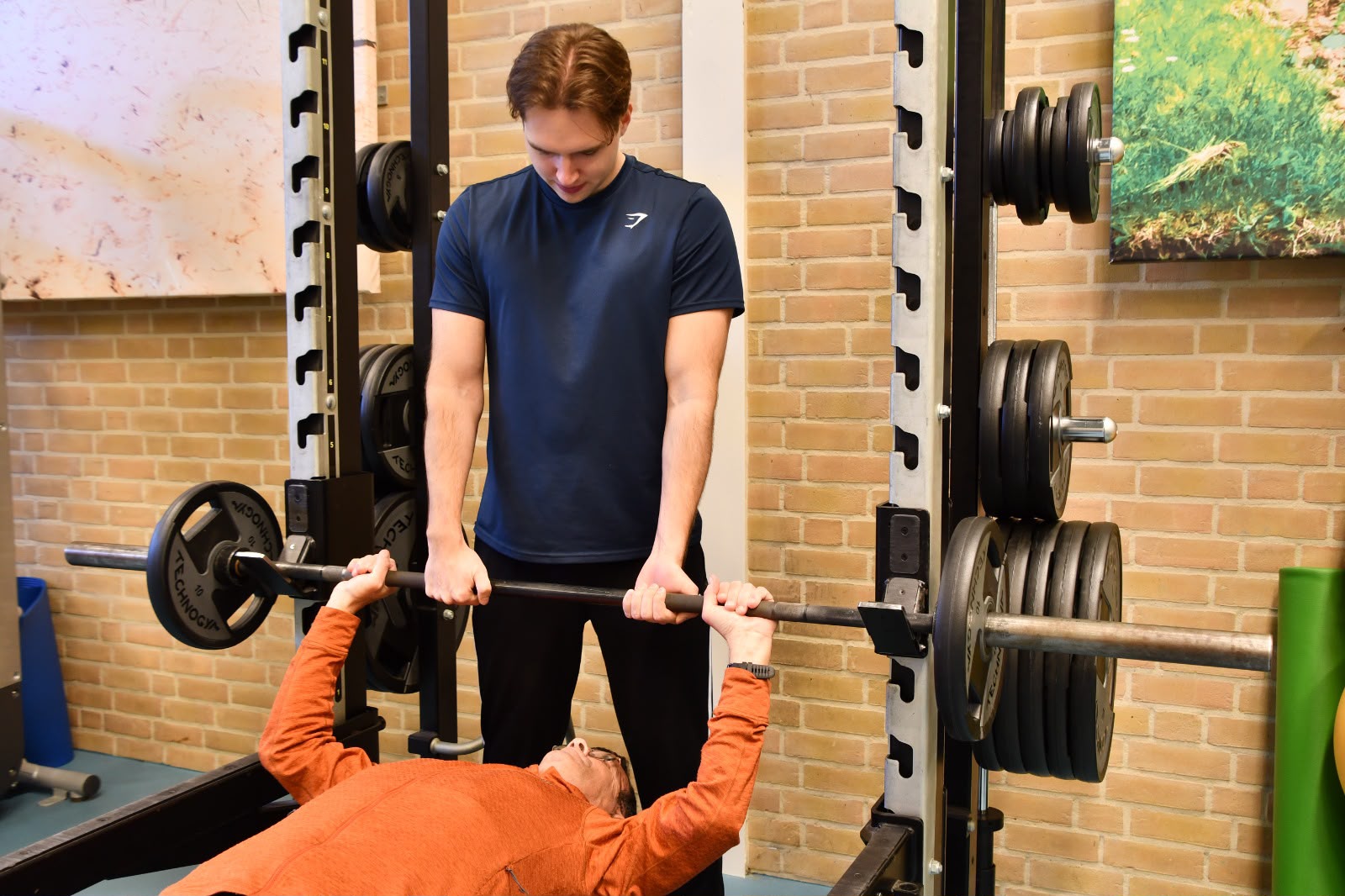 Personal trainer Steven geeft techniekcoaching bij een barbell-oefening